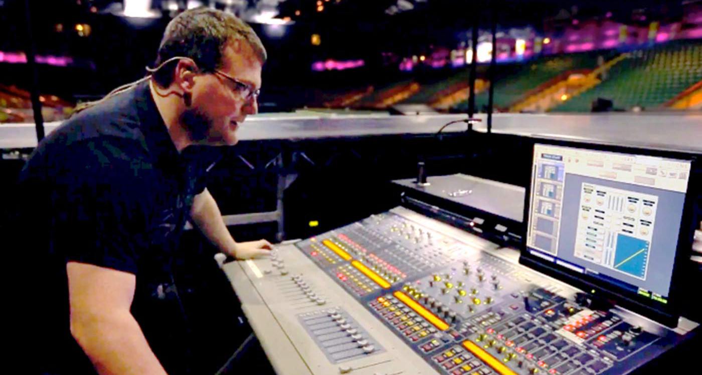James Baker operating a monitor desk in an empty stadium preparing for a gig James Baker operating a monitor desk in an empty stadium preparing for a gig