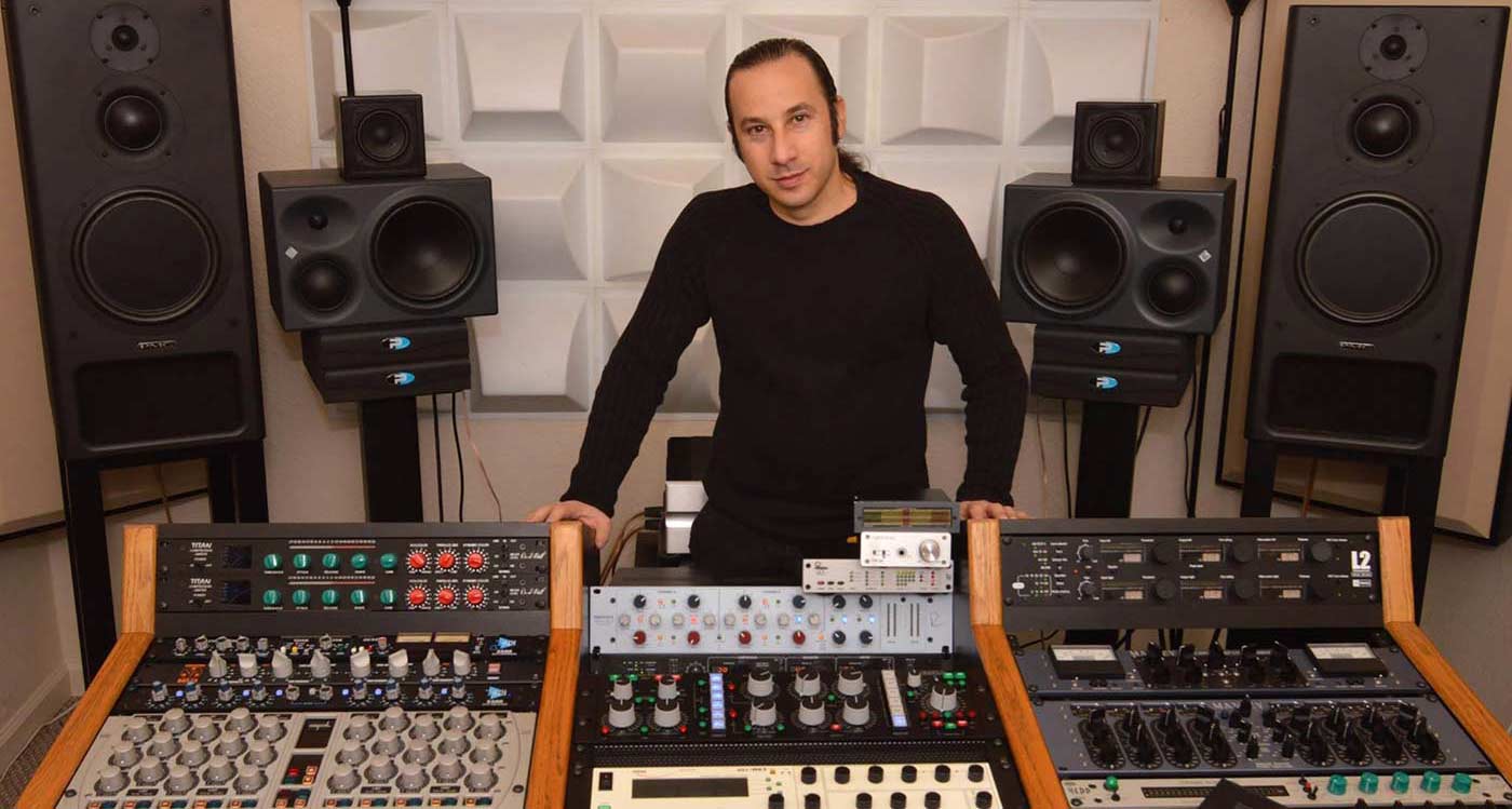Maor Appelbaum stood behind mixing desk in between two large speakers Maor Appelbaum stood behind mixing desk in between two large speakers