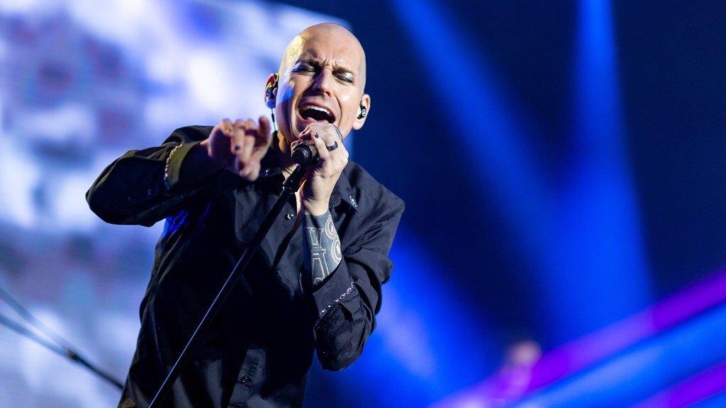 Tony Vincent singing heartfelt into a microphone at a concert Tony Vincent singing heartfelt into a microphone at a concert